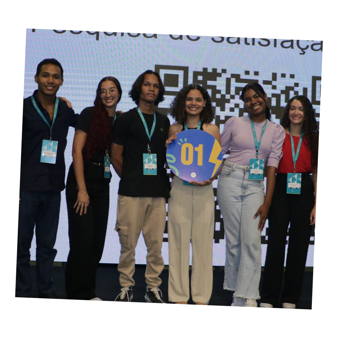 Grupo de voluntários e estudantes sorrindo em evento da Junior Achievement Brasil